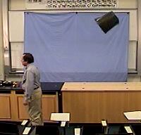 A trashcan is tossed through the air, tumbling along the way.